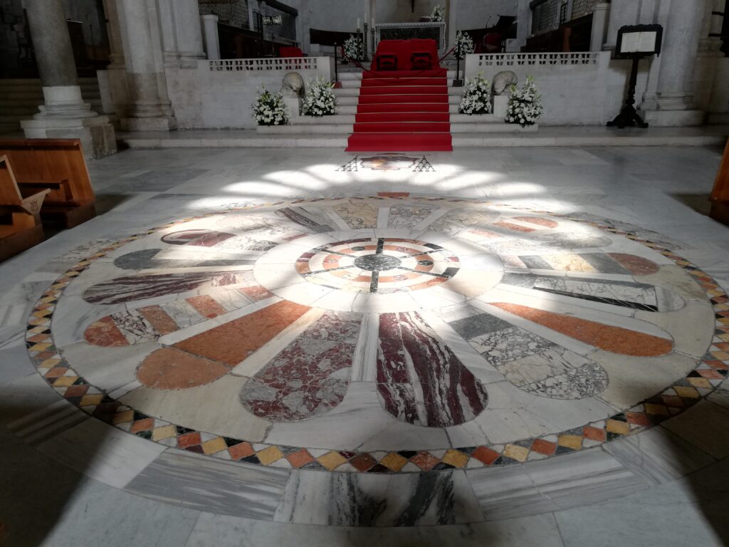 Bari catedral, el 21 de junio dia del solsticio de verano la luz que penetra por la fachada dibuja en el suelo un roseton de luz y sombra encima de marmoles policromado de la edad media